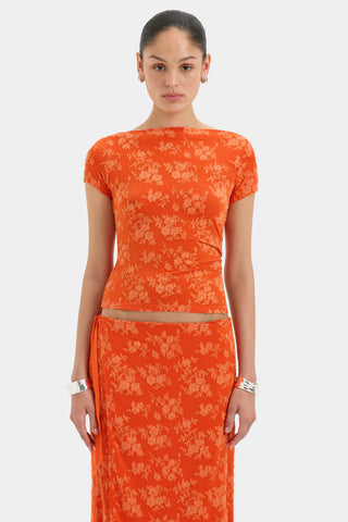 Bright orange fitted top with short sleeves and a floral pattern.