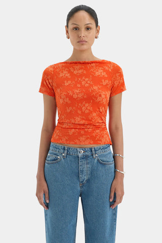 Bright orange fitted top with short sleeves and a floral pattern.