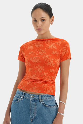 Bright orange fitted top with short sleeves and a floral pattern.