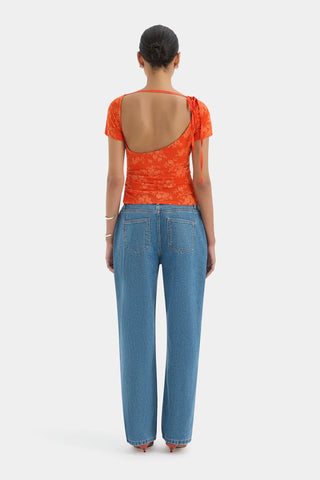 Bright orange fitted top with short sleeves and a floral pattern.